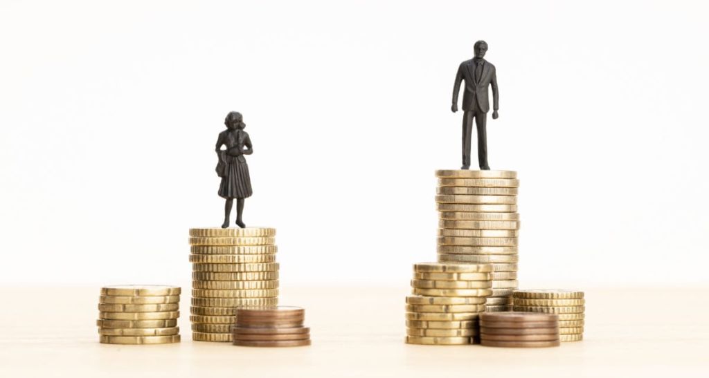 Gender Wage gap concept Man and woman figurines standing on top of the pile of coins